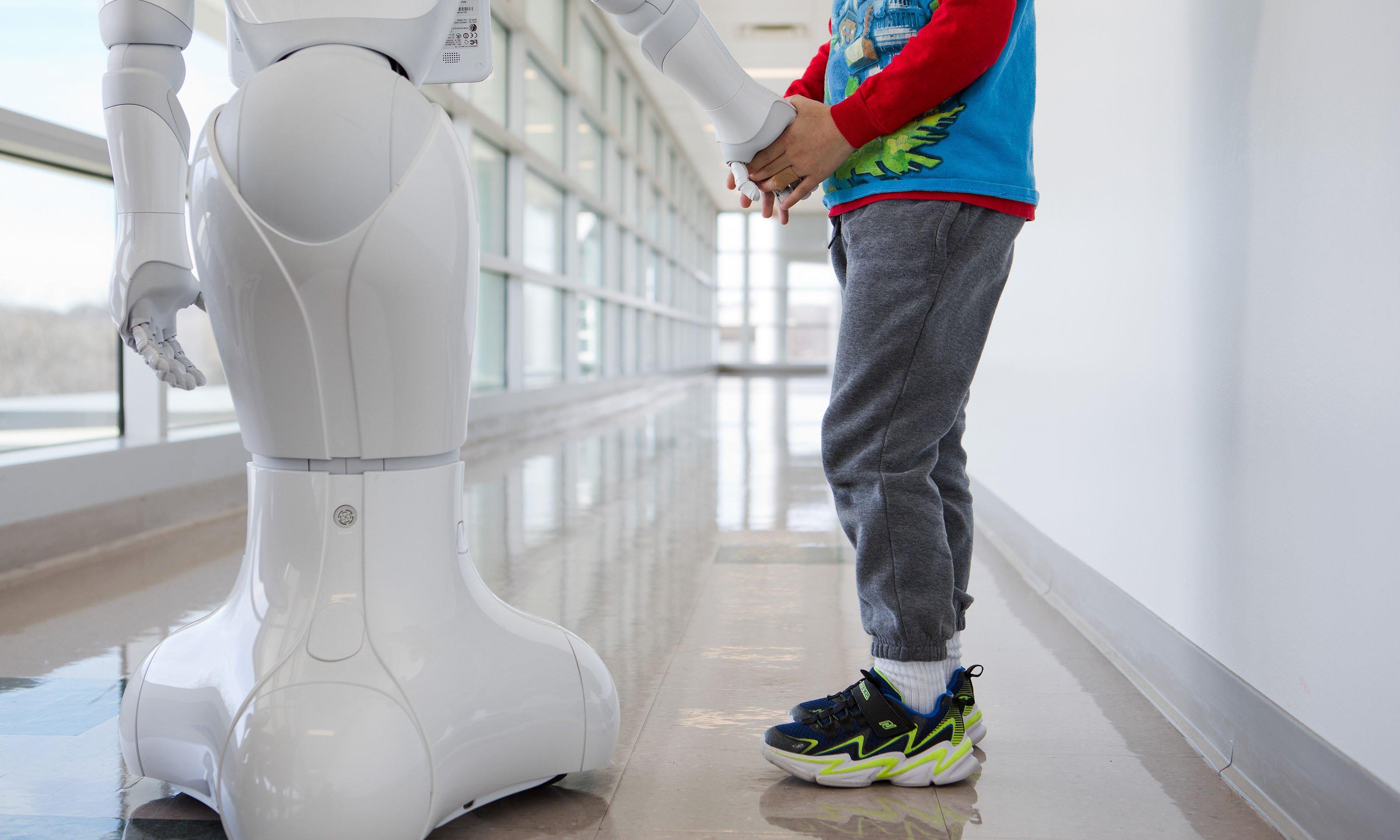Child holding robot's hand